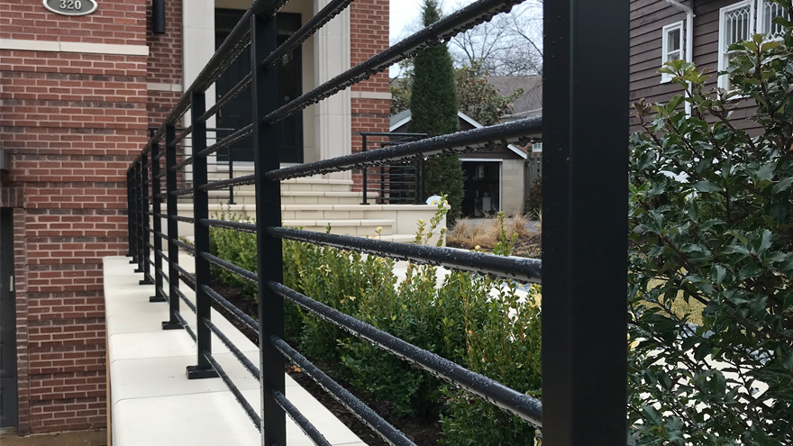 Black powder coat railing system top mounted on concrete.